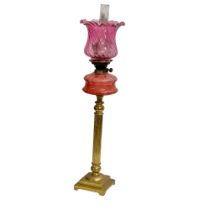 A large Victorian oil lamp with Cranberry Glass bowl, brass column and later shade. 89cm