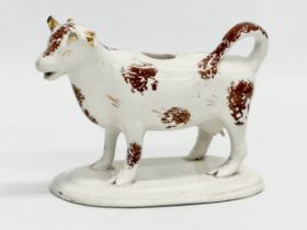 A early/mid 19th century Staffordshire Pottery Cow Creamer. 16x11cm