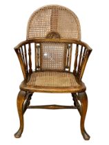 An early 20th century Elm armchair with bergere back and seat. Circa 1920.