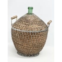 A large vintage wicker and metal bound glass carboy bottle. 44x40x56cm