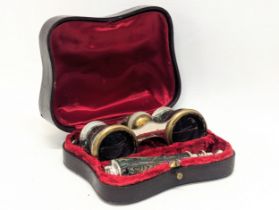 A pair of vintage abalone opera glasses with extending handle in case.