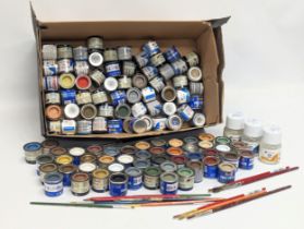 A collection of paints, paintbrushes, and 2 Humbrol Matt Cote, a Humbrol Enamel Thinner. Paint