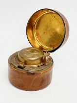 A Victorian brass and leather bound travel inkwell. 5x4cm