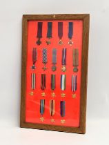 A collection of miniature World War I and World War II medals in display case.