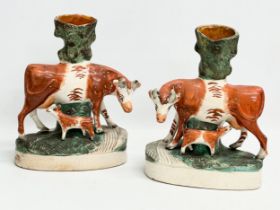 A pair of mid/late 19th century Staffordshire Cow spill vases. 22x27.5cm