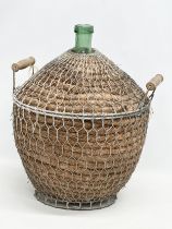 A large vintage wicker and metal bound glass carboy bottle. 44x40x56cm