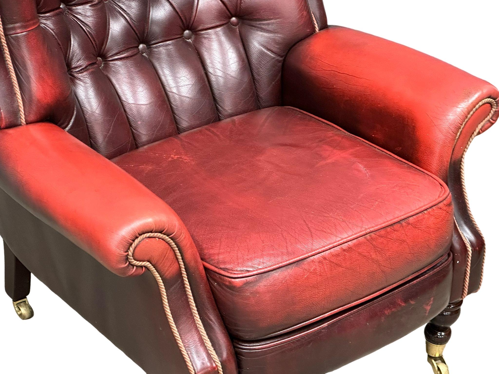 A Victorian style deep buttoned ox blood leather armchair on brass cup casters. 85x75x93cm - Image 3 of 4
