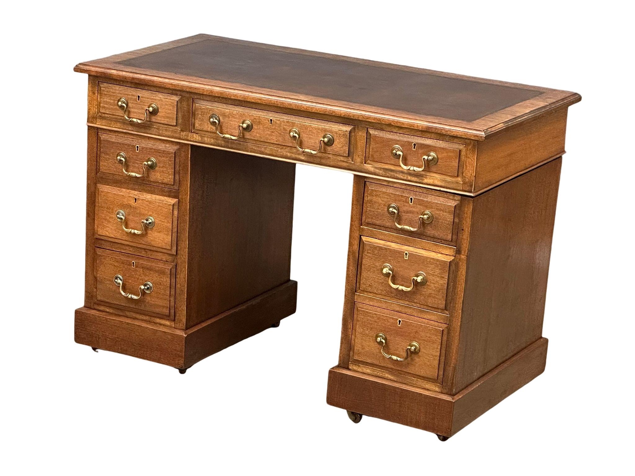 A late Victorian pedestal writing desk with leather top, circa 1890-1900. 106cm x 56cm x 73cm.