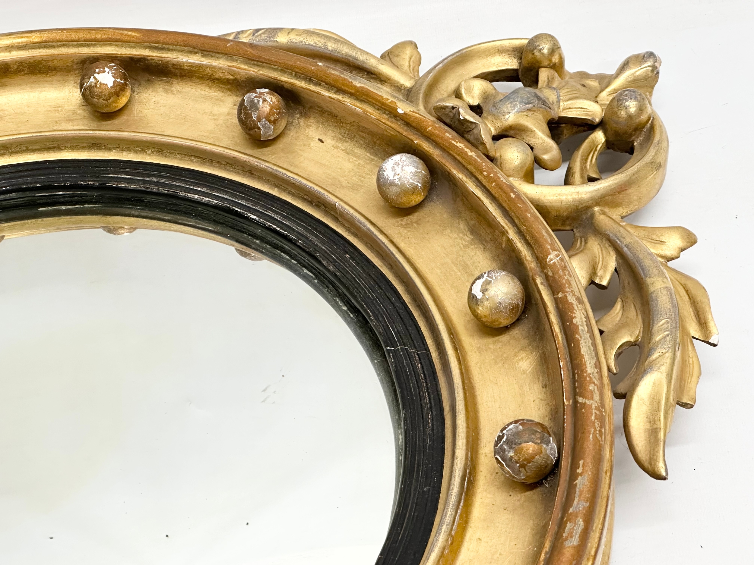An early 19th century Regency period gilt framed convex mirror with an early 20th century back. - Image 2 of 7