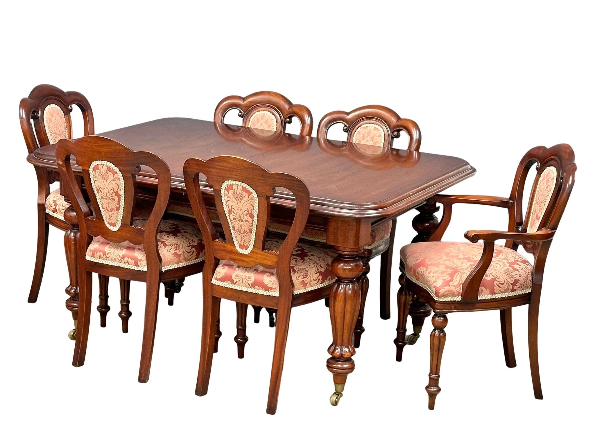 A large Victorian style mahogany 2 leaf extending dining table with 6 balloon back chairs on