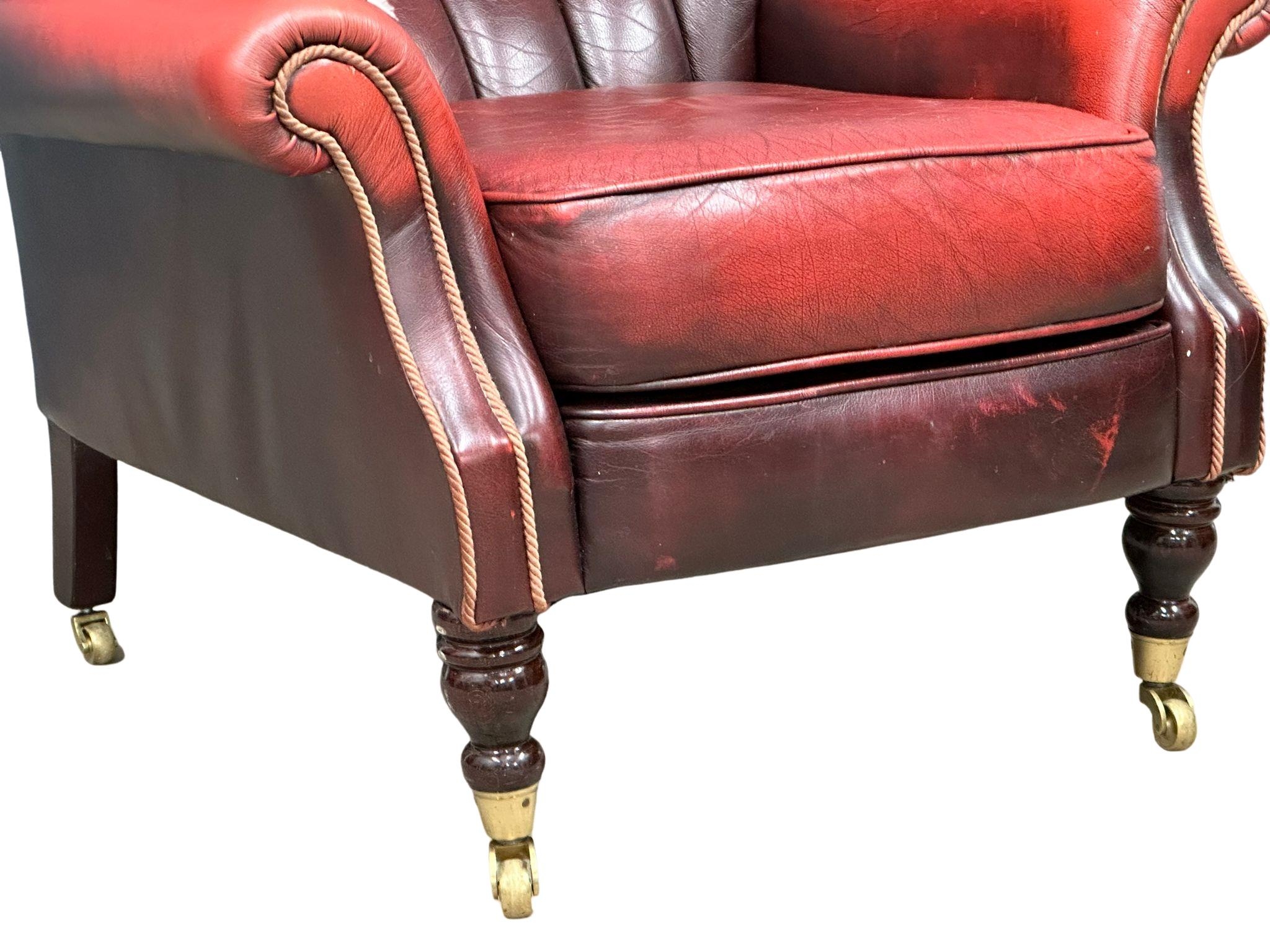 A Victorian style deep buttoned ox blood leather armchair on brass cup casters. 85x75x93cm - Image 4 of 4
