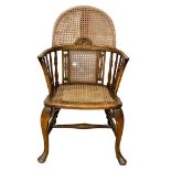 An early 20th century Elm armchair with bergere back and seat. Circa 1920.