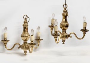 A pair of heavy brass chandeliers. 52x46cm