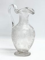 An etched glass pitcher in the manner of William Fritsche. Decorated with leaves, grape vines and