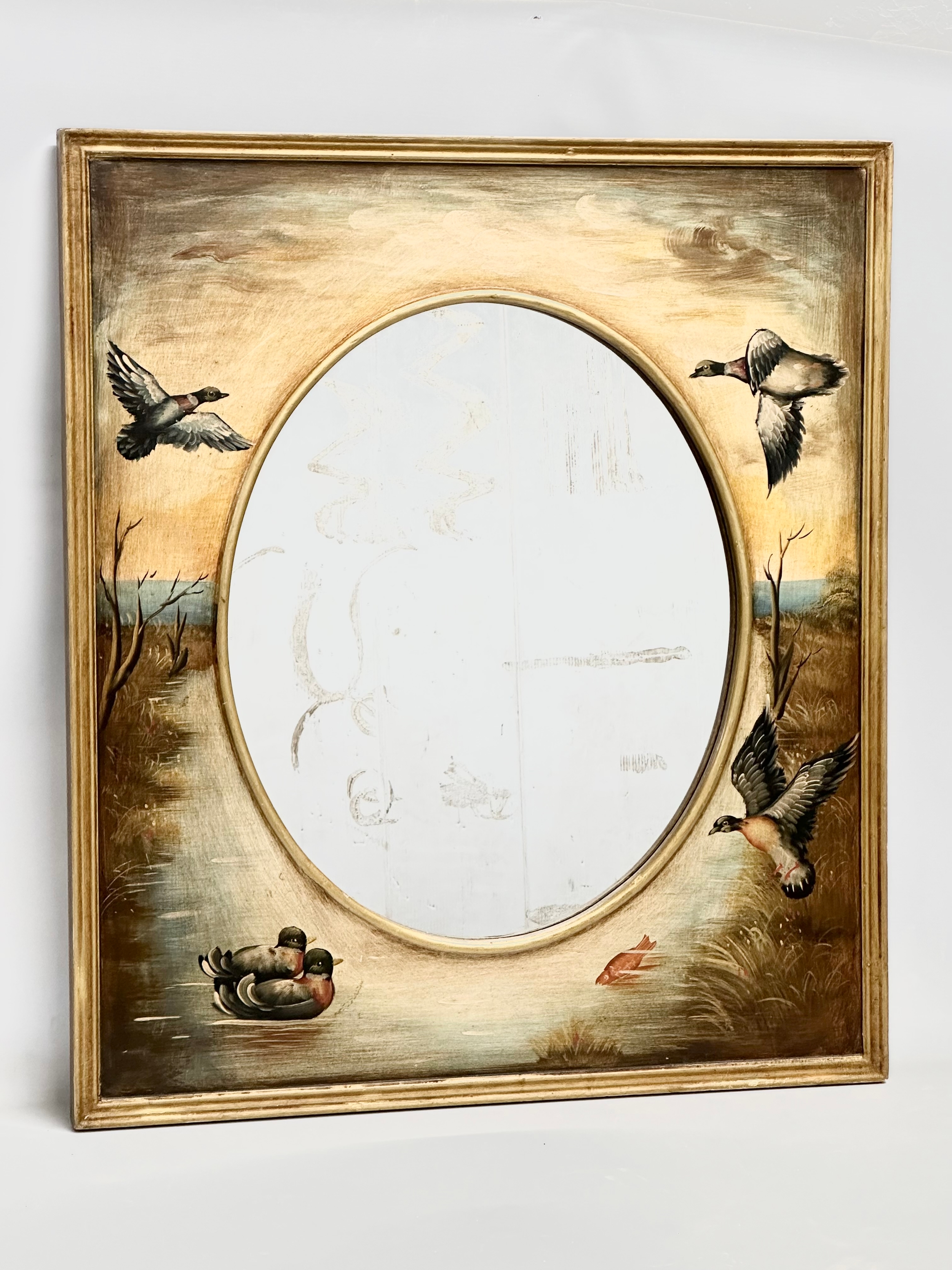 A large good quality gilt framed mirror with painted ducks and birds in flight. 77x88cm C