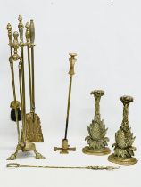 A quantity of Late Victorian brass fire tools and doorstops. A large Victorian brass companion set