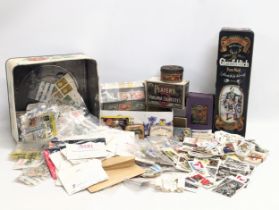 A large collection of 20th Century international stamps, tins, cigarette cards, etc.