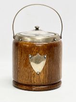 An early 20th century oak and silver plated biscuit barrel.