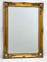 A large Victorian style gilt framed bevelled mirror by J.R. Annett. 66x91cm