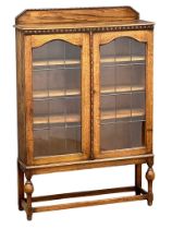 A 1930’s oak bookcase with lead astragal glazed doors and adjustable shelves. 91x25x137.5cm
