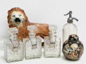 A job lot. Including a vintage soda syphon, a large Staffordshire lion, 3 decanter and a Chinese