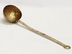 An early 19th century brass cream skimmer. Circa 1800-1820. 46cm