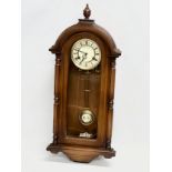 A 19th century style Schmeckenbecker wall clock. With key and pendulum. 63cm