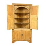 A large late George III pine corner cabinet with fitted shelves and architectural interior. Circa