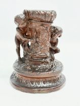 A 19th Century glazed ceramic cherub candleholder. 13x15cm