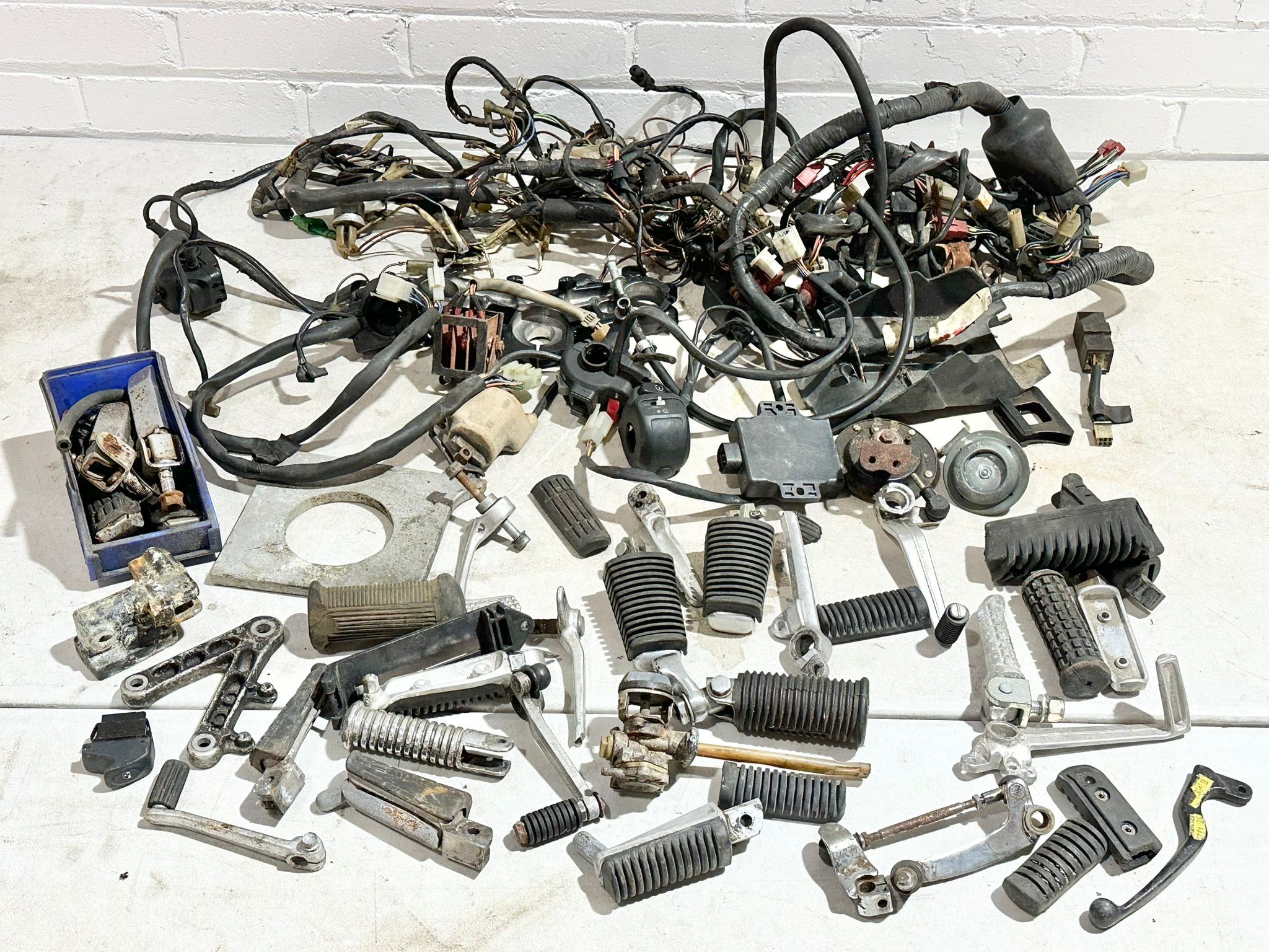 A sundry lot of various motorbike electrical parts with foot rests etc