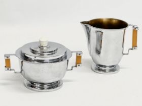 An Art Deco chromium plated sugar bowl and matching milk jug.