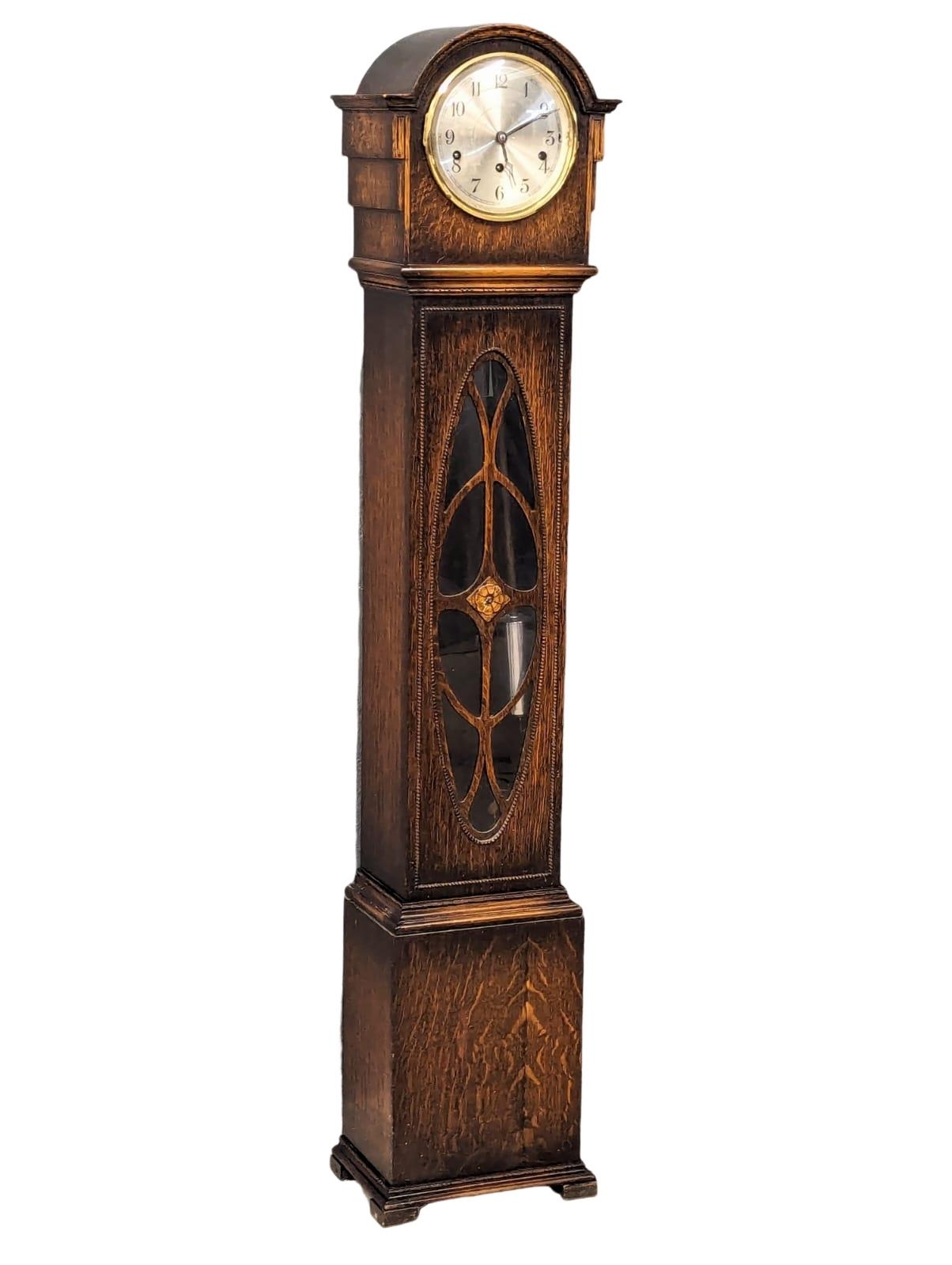 A 1930s oak cased granddaughter clock with West Minister chimes. With pendulum and key. 142cm