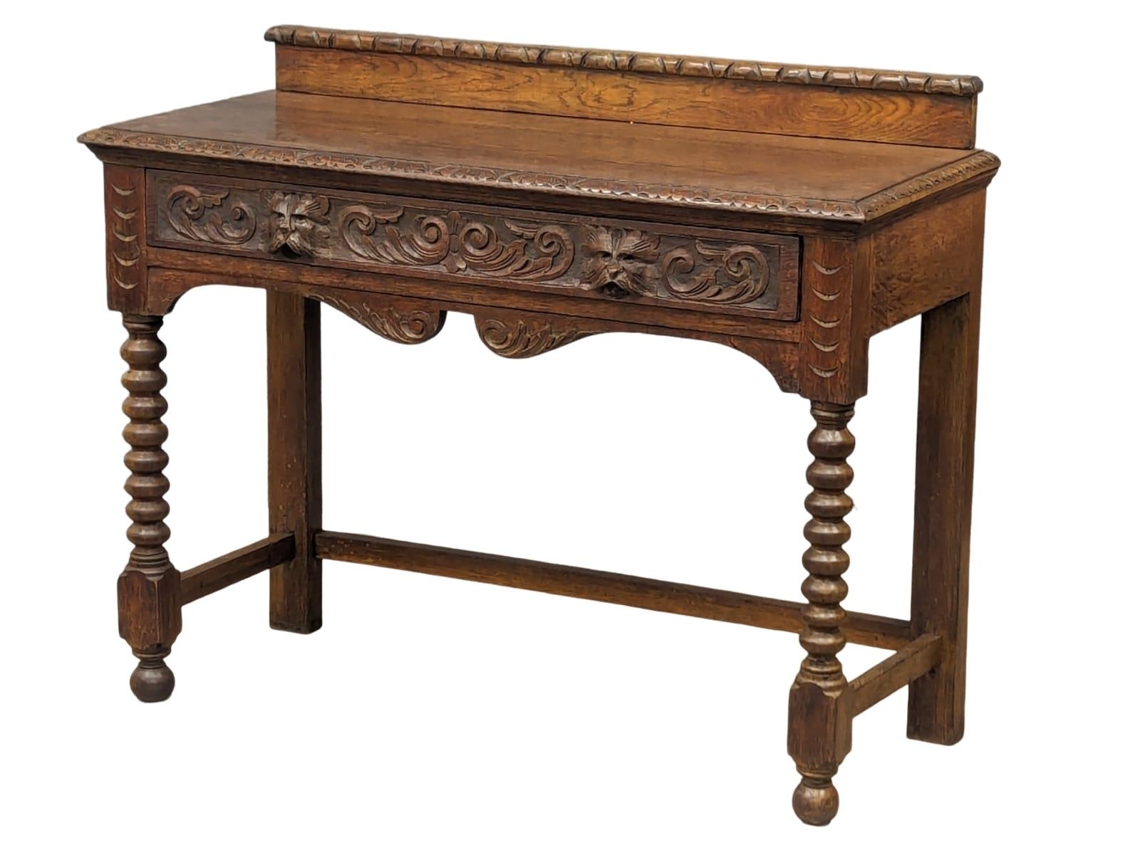 A late Victorian carved oak hall table with bobbin turn legs and Man Of The Forest handles, 107cm