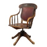 An Early 20th Century oak swivel desk chair with leather back. Circa 1900.