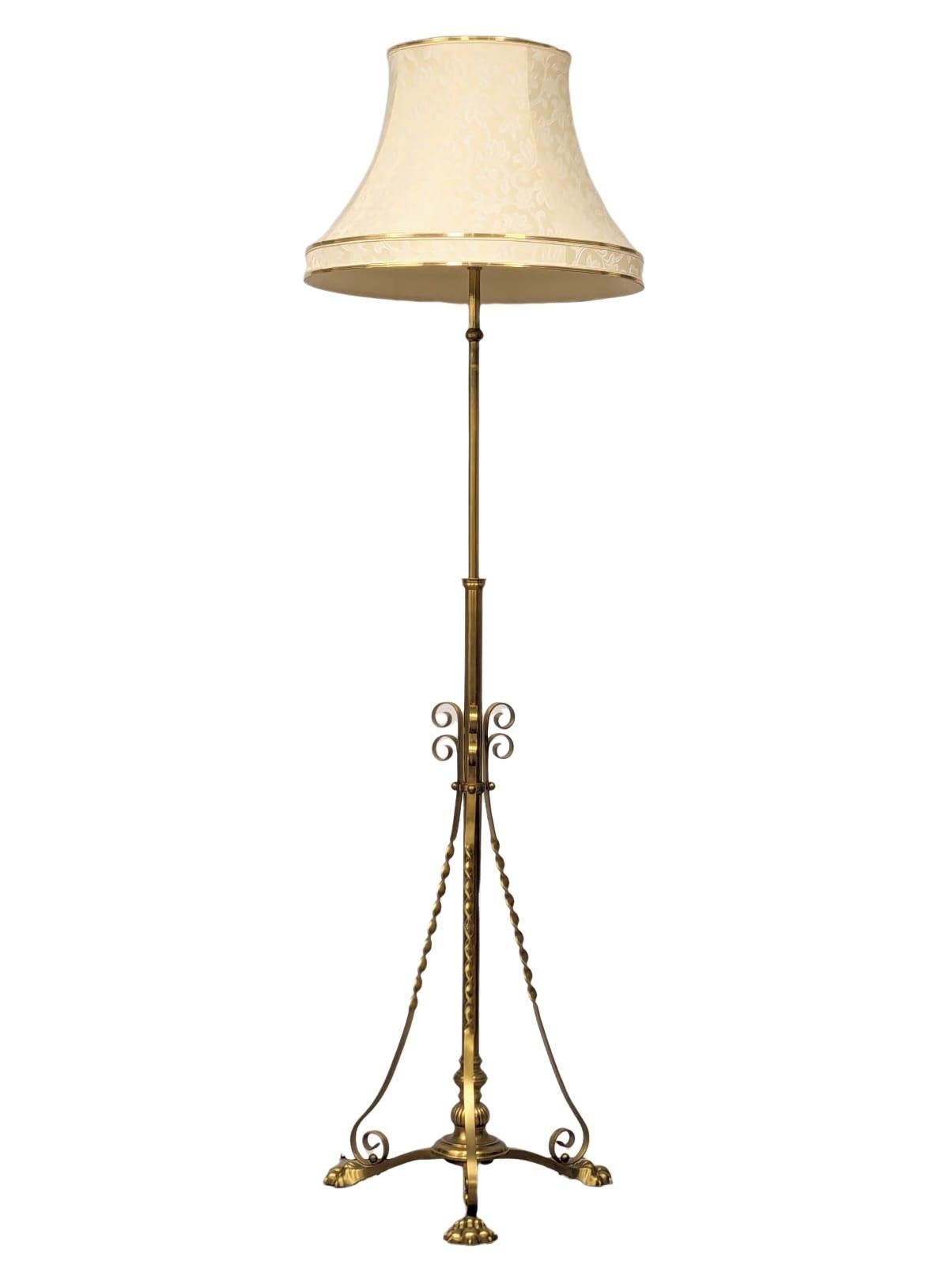 A large Early 20th Century telescopic brass standard lamp on brass lion paw feet. 180cm