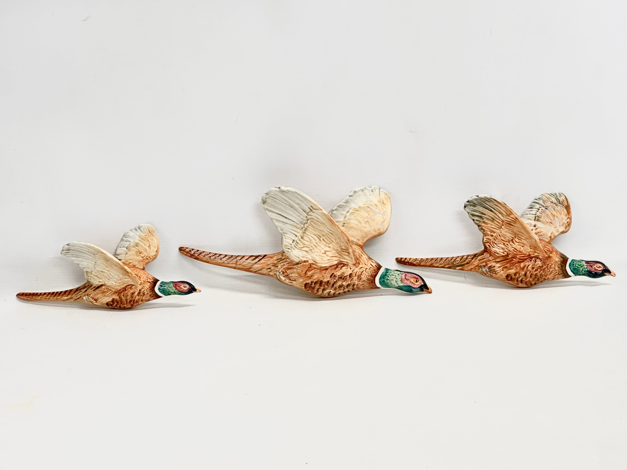 A set of 3 Beswick flying pheasant wall plaques. Largest 30cm