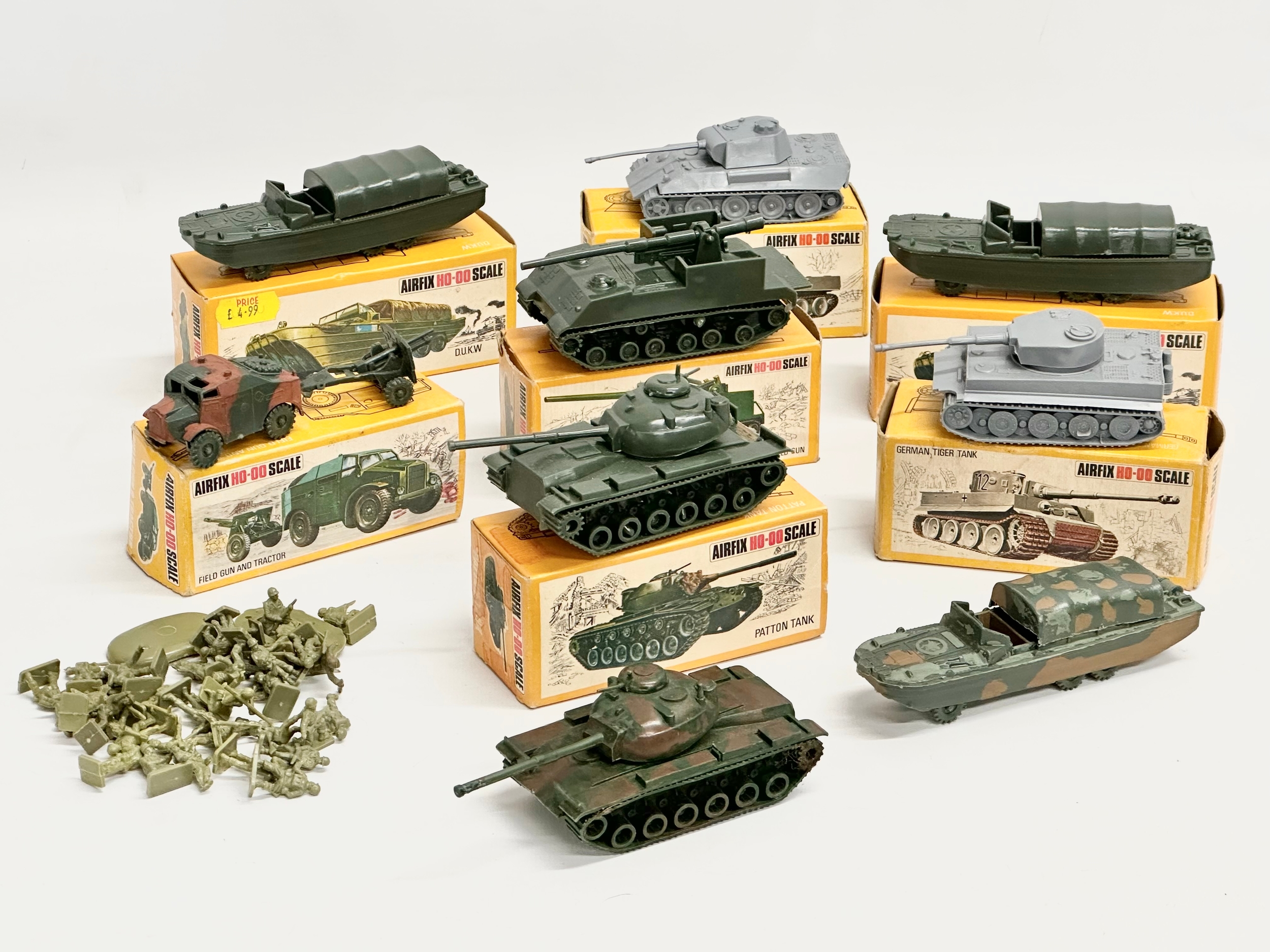 A collection of vintage Airfix HO-OO scale vehicles with boxes and soldiers.