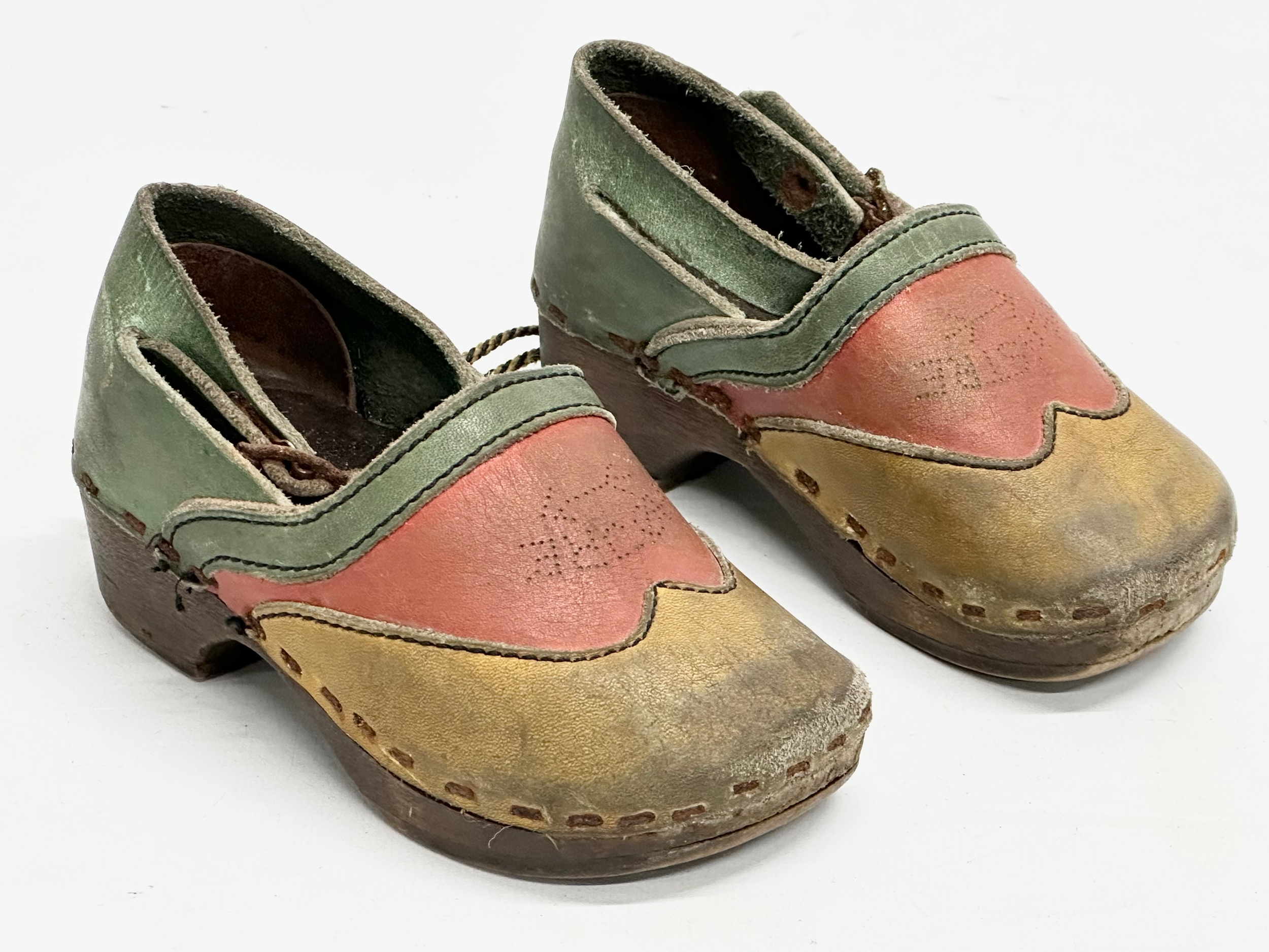 A pair of vintage child’s Folk Art leather and wooden clogs.