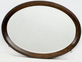 A large vintage oak framed bevelled mirror. 107x77cm