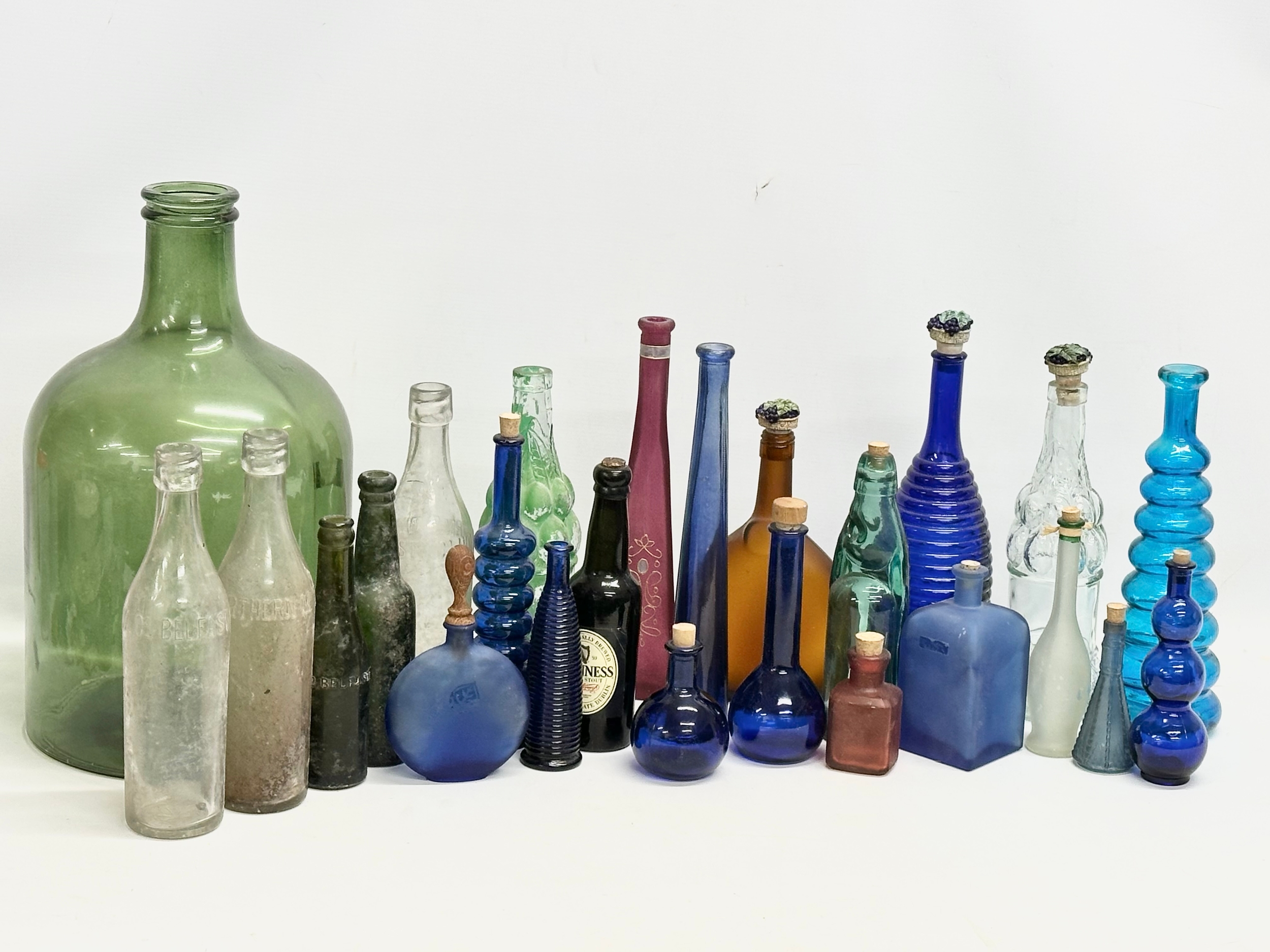 A collection of vintage glass bottles. Belfast water bottles, carboy etc