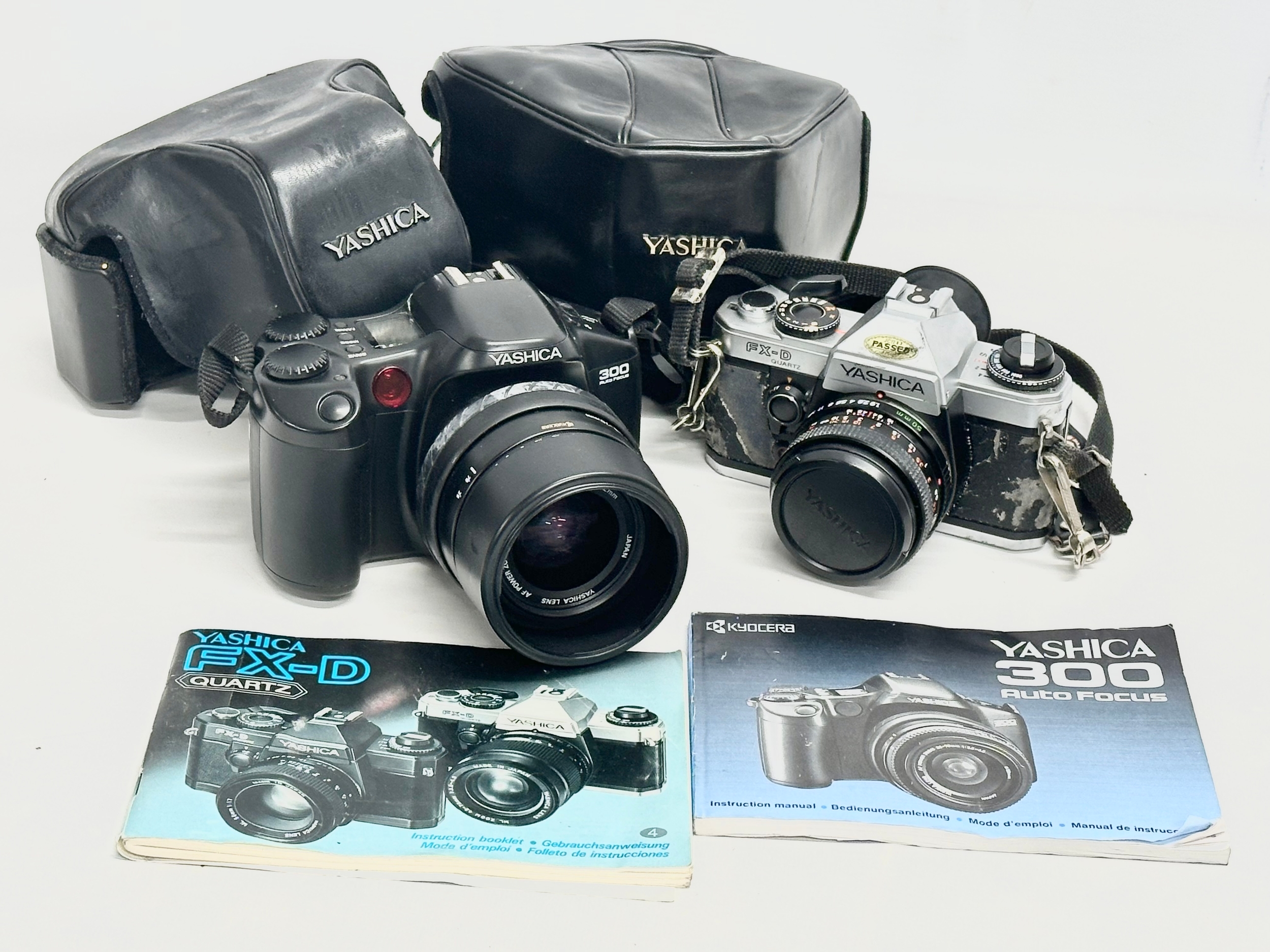 2 Yashica cameras. A Yashica 300 Auto Focus camera with case and book. A Yashica FX-D Quartz