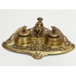 A Late 19th Century brass inkstand/inkwell with sitting putti and pierced brass base. 32x20x11cm