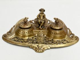 A Late 19th Century brass inkstand/inkwell with sitting putti and pierced brass base. 32x20x11cm