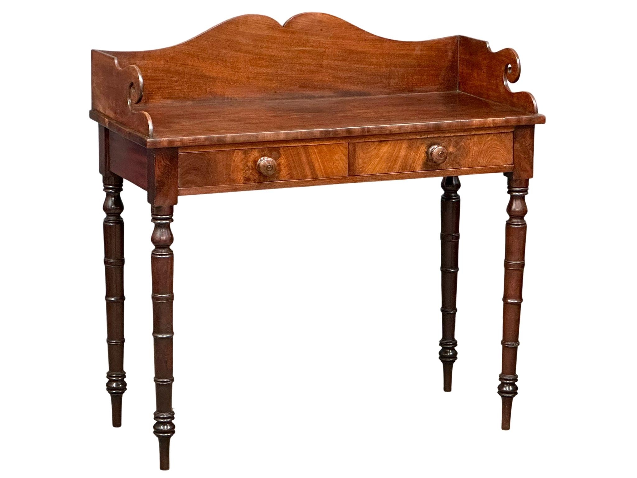 A late George IV mahogany gallery back side table on reeded legs, containing 2 front facing drawers.