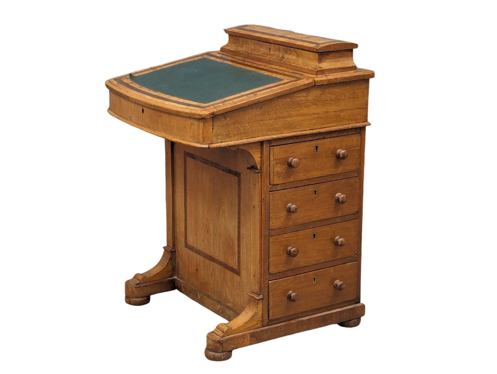 A Victorian walnut Davenport desk with maple interior.