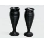 A pair of Late 19th Century turned ebony candleholders/vases. 16cm.