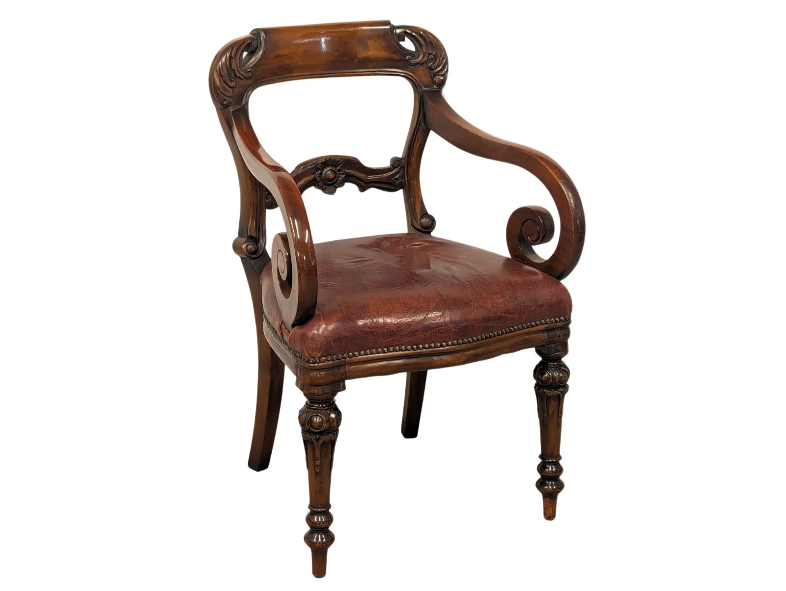 A William IV style mahogany armchair with scroll arms and leather seat