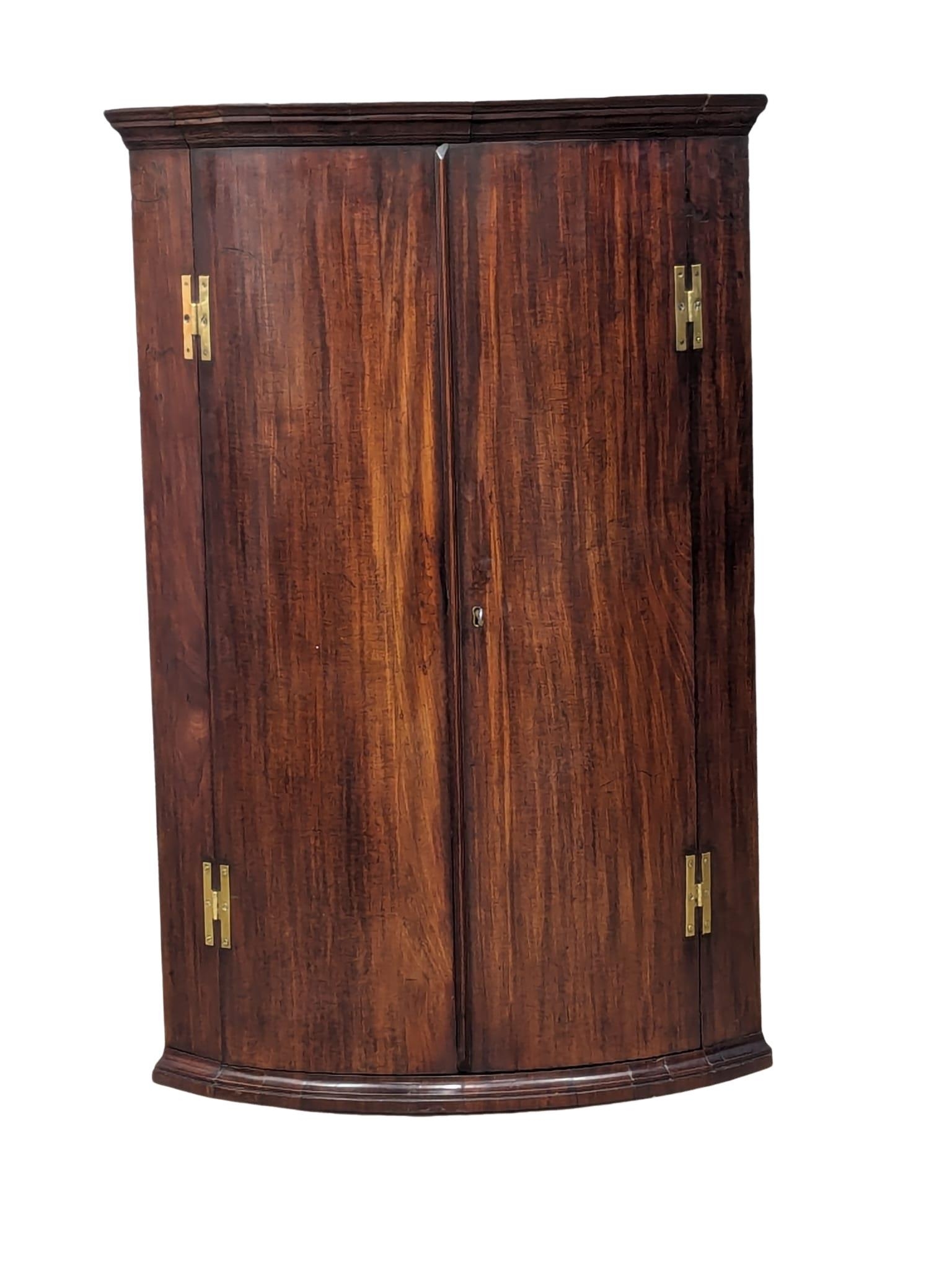 A George III mahogany wall hanging corner cabinet with 3 fitted shelves and drawers. Circa 1790.