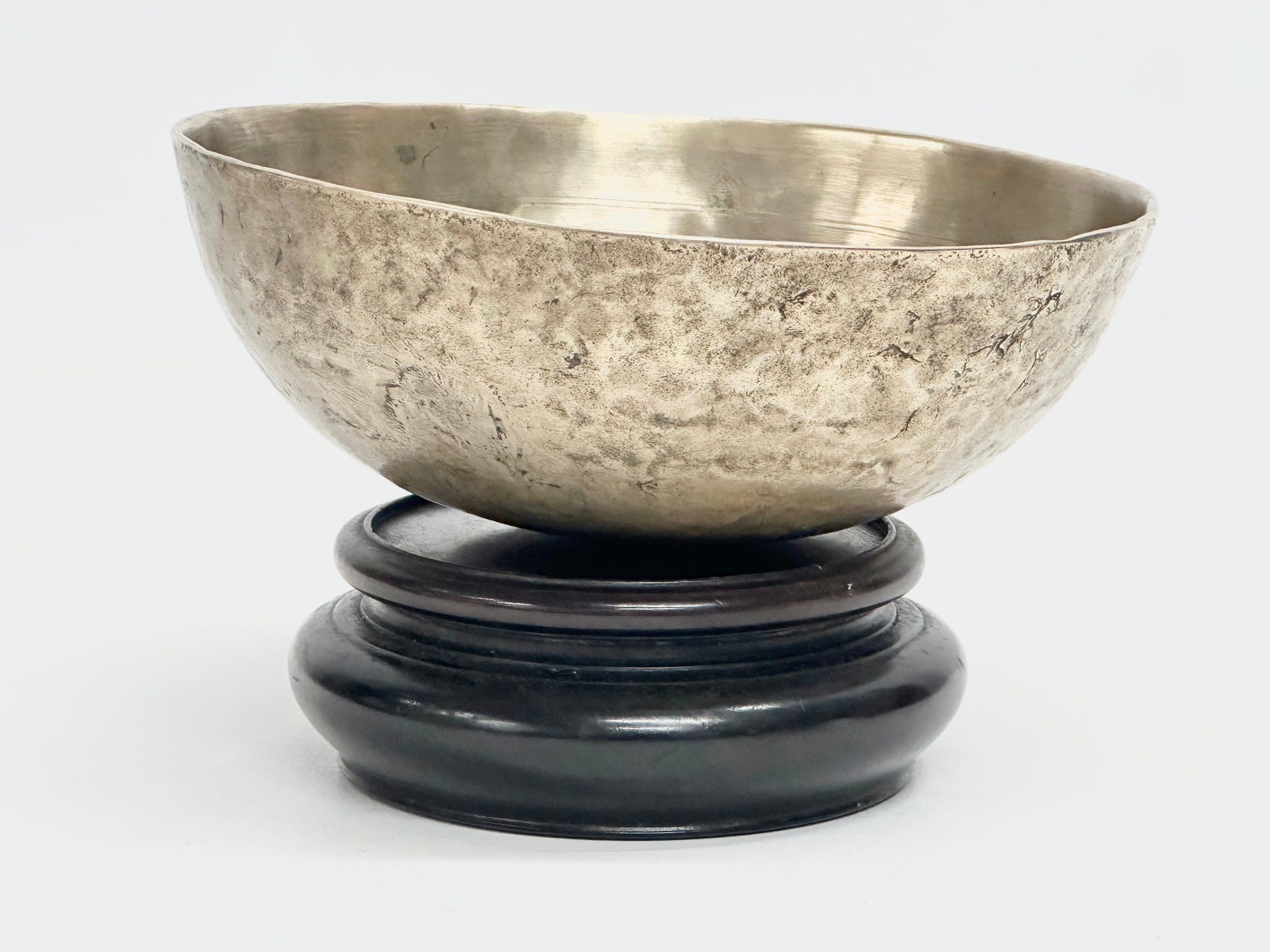 A Late 19th Century Tibetan Singing bowl on stand. Bowl measures 16x6cm