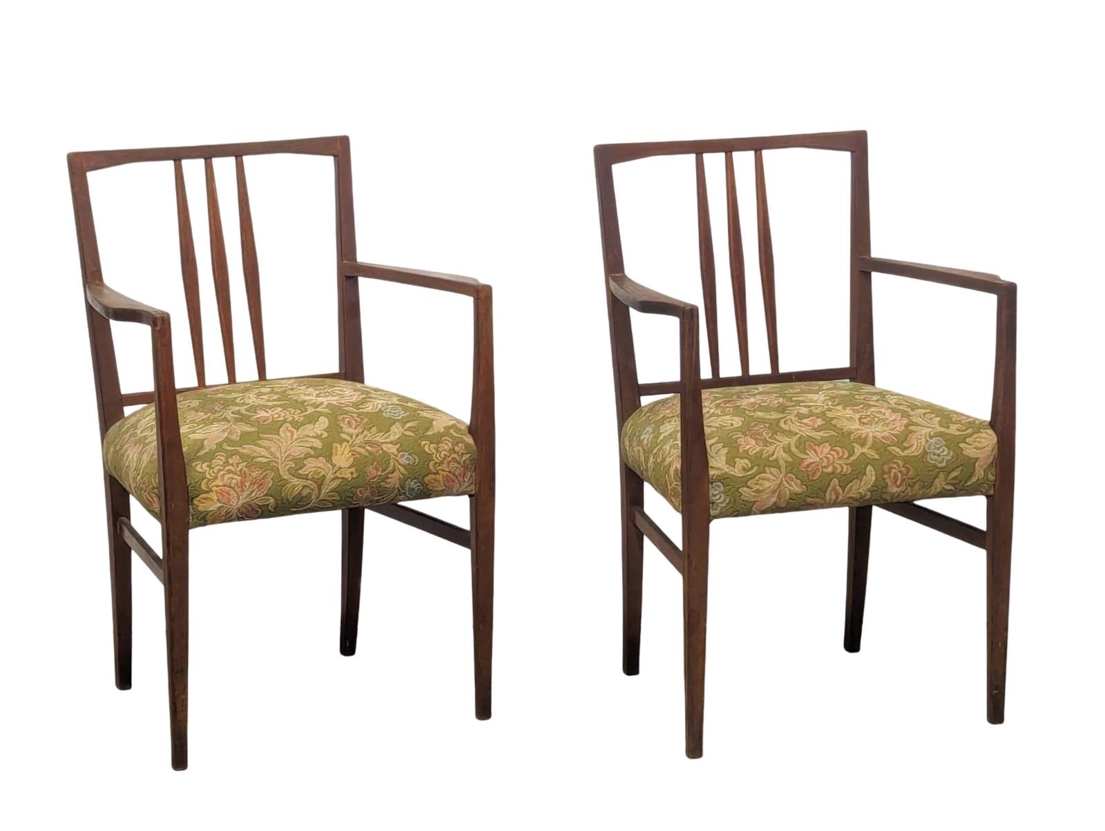 A pair of Mid Century teak armchairs designed by Gordon Russell.